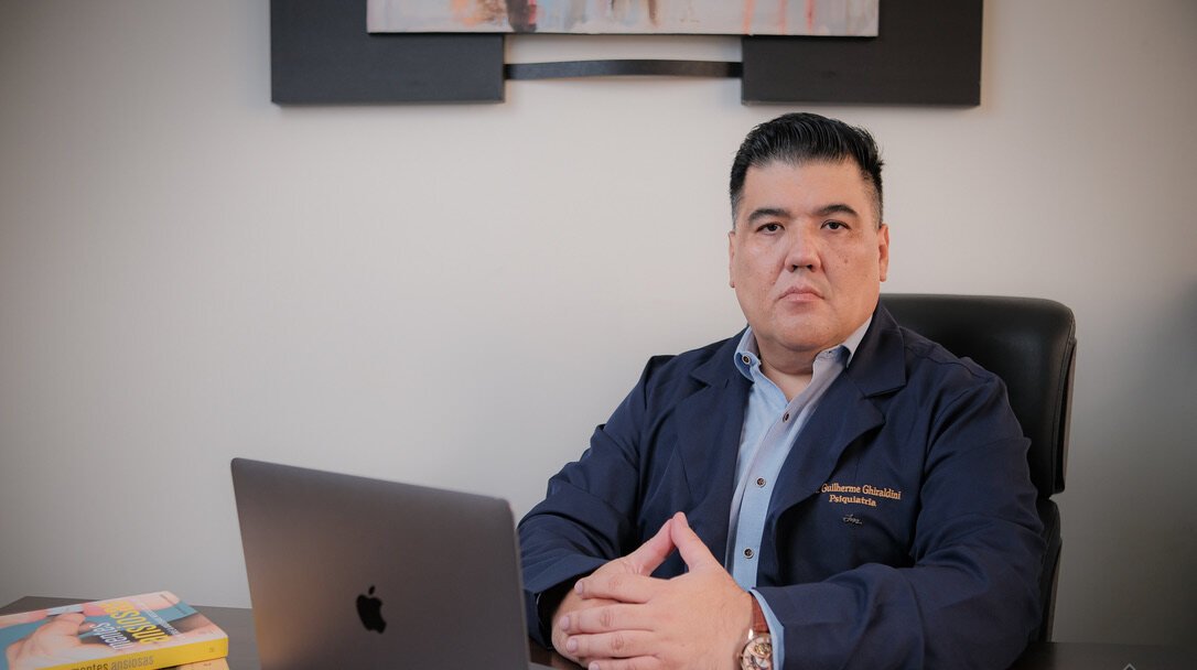 Dr. Guilherme Ghiraldini em seu consultório, durante atendimento